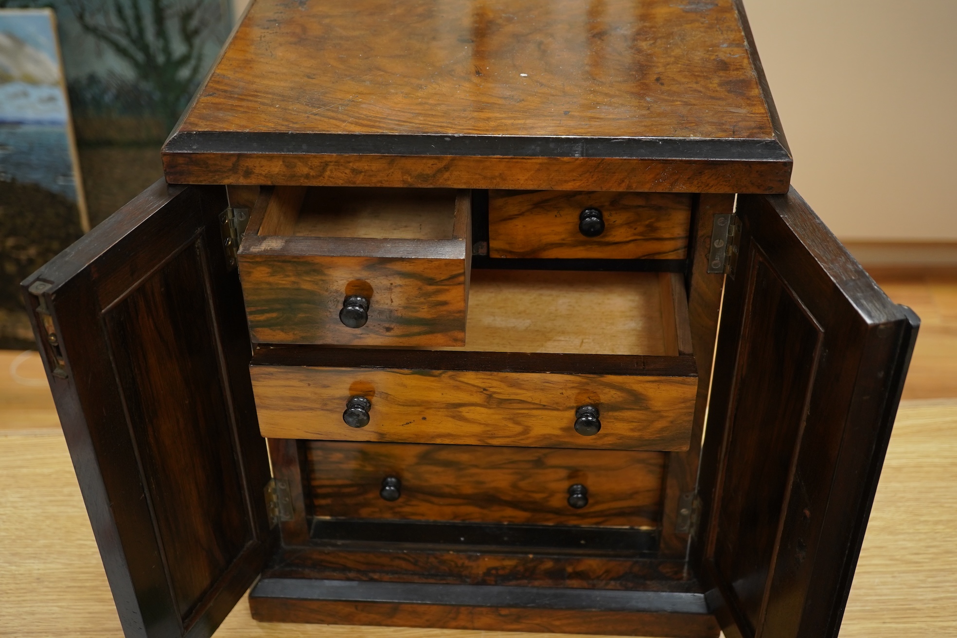 A Victorian walnut miniature two door tabletop cabinet/chest with two short and three long drawers inside. 32cm wide x 37cm high